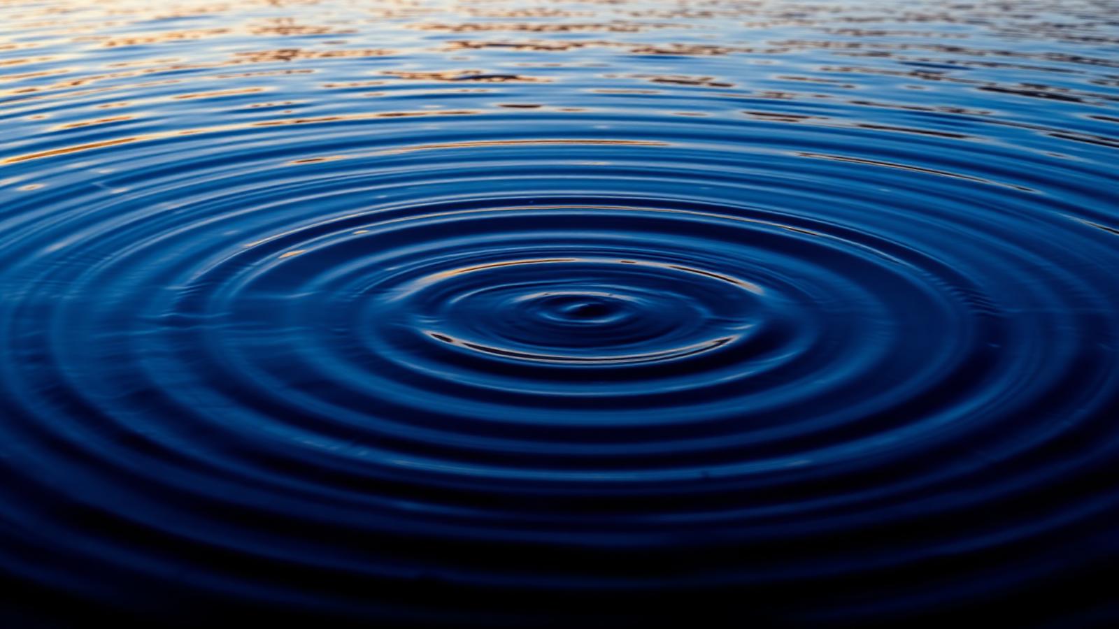 Calm deep-blue water with concentric ripples spreading outwards